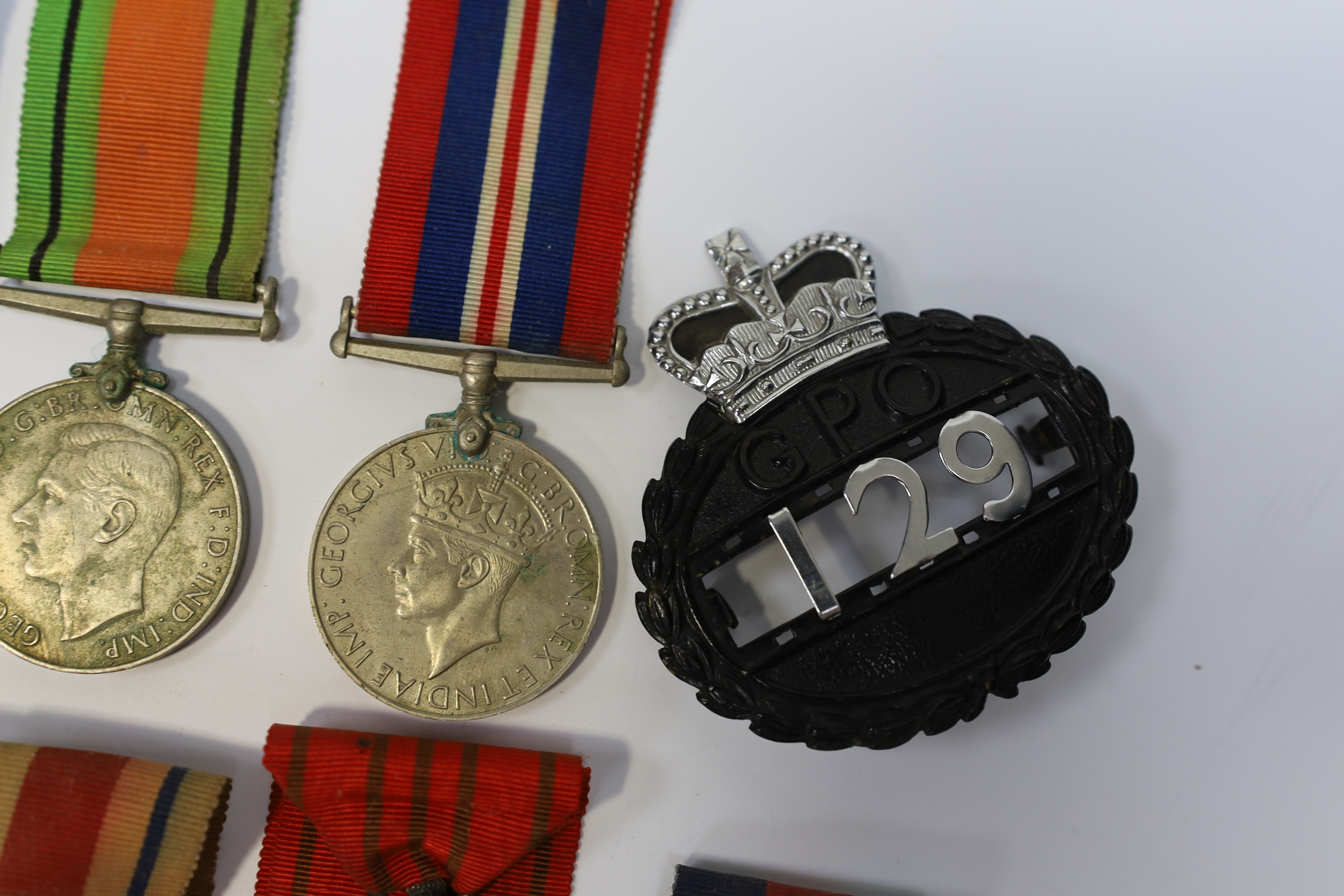 Seven medals including; a First World War British War Medal awarded to PTE. H. Lee DURH. L.I., A 1939-1945 medal, The Defence Medal, the Africa Star, the France and Germany Star, the 1939-1945 Star, plus a GPO cap badge.